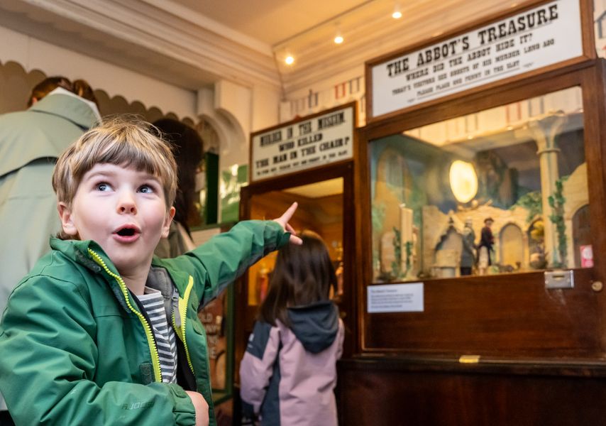A child pointing at a penny arcade machine