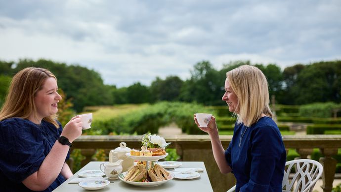 Two people sat at a table enjoying afternoon tea on Temple Newsam's terrace