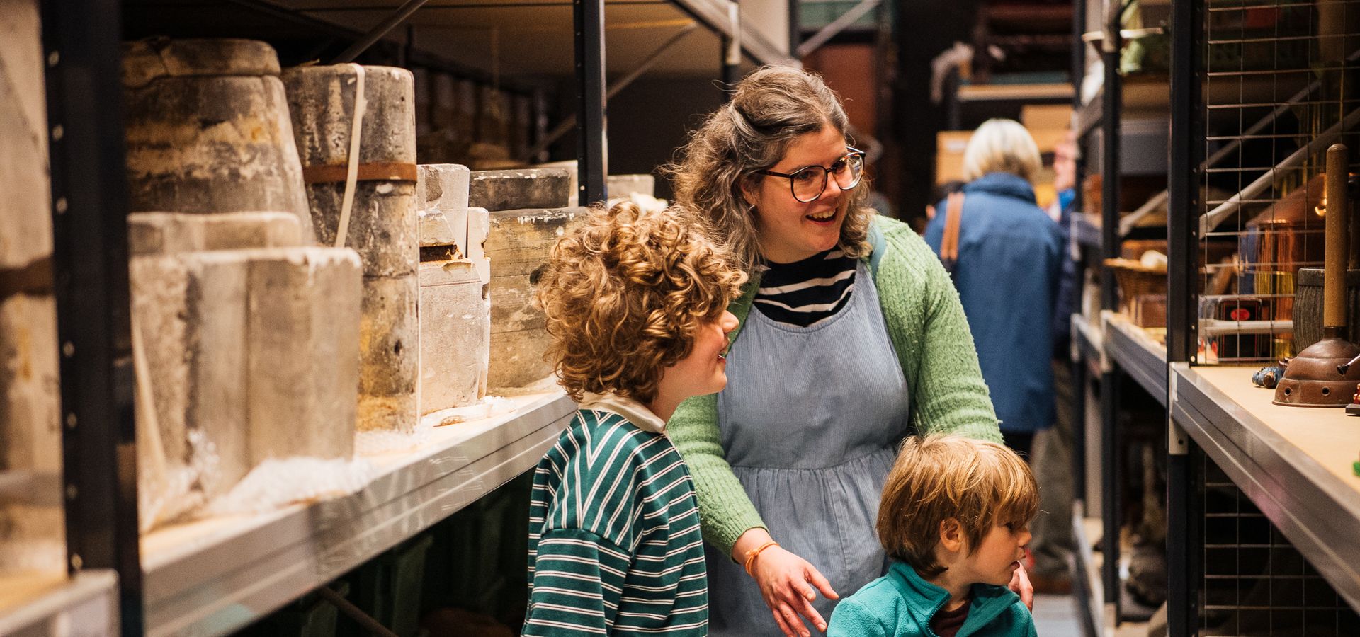 An adult and 2 children looking at display shelves at Leeds Discovery Centre