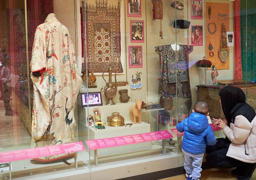An adult and child looking at a World Cultures display in Leeds City Museum