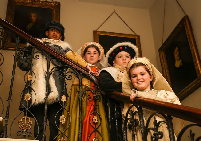 students in tudor costumes on Temple Newsam house stairs.