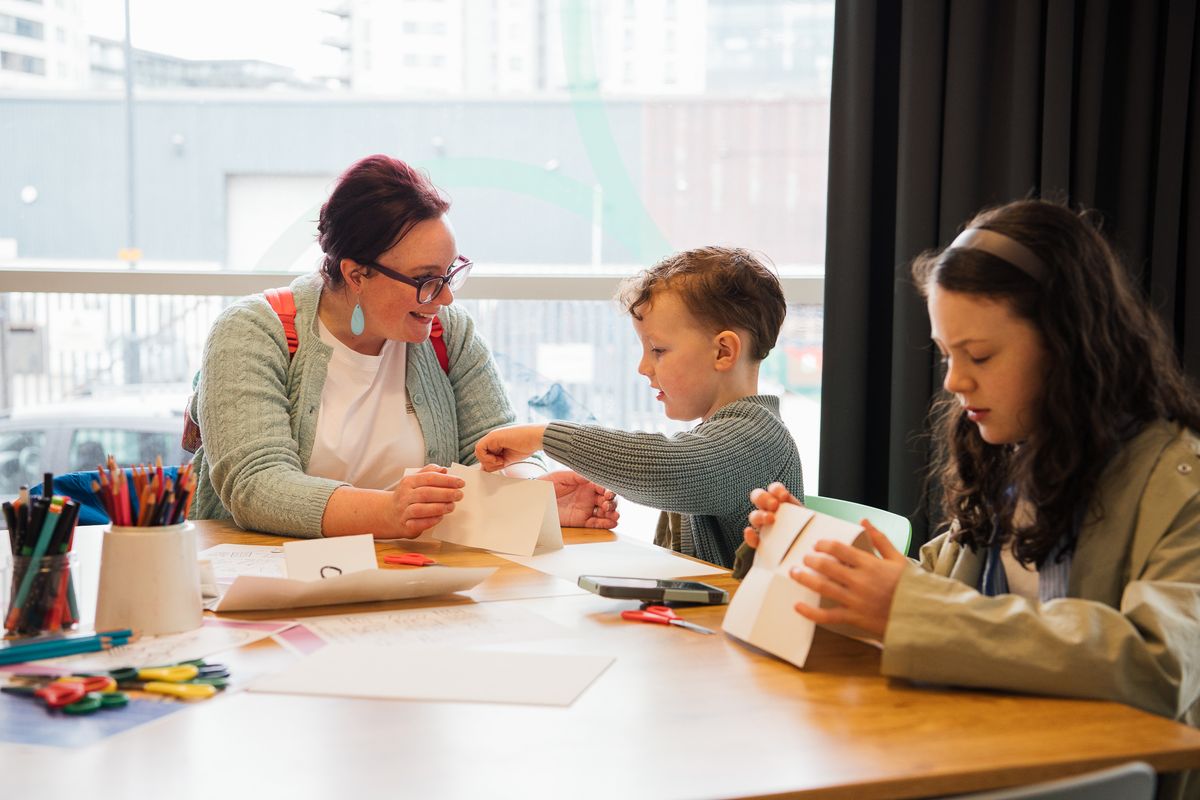 An adult and 2 children doing craft activites