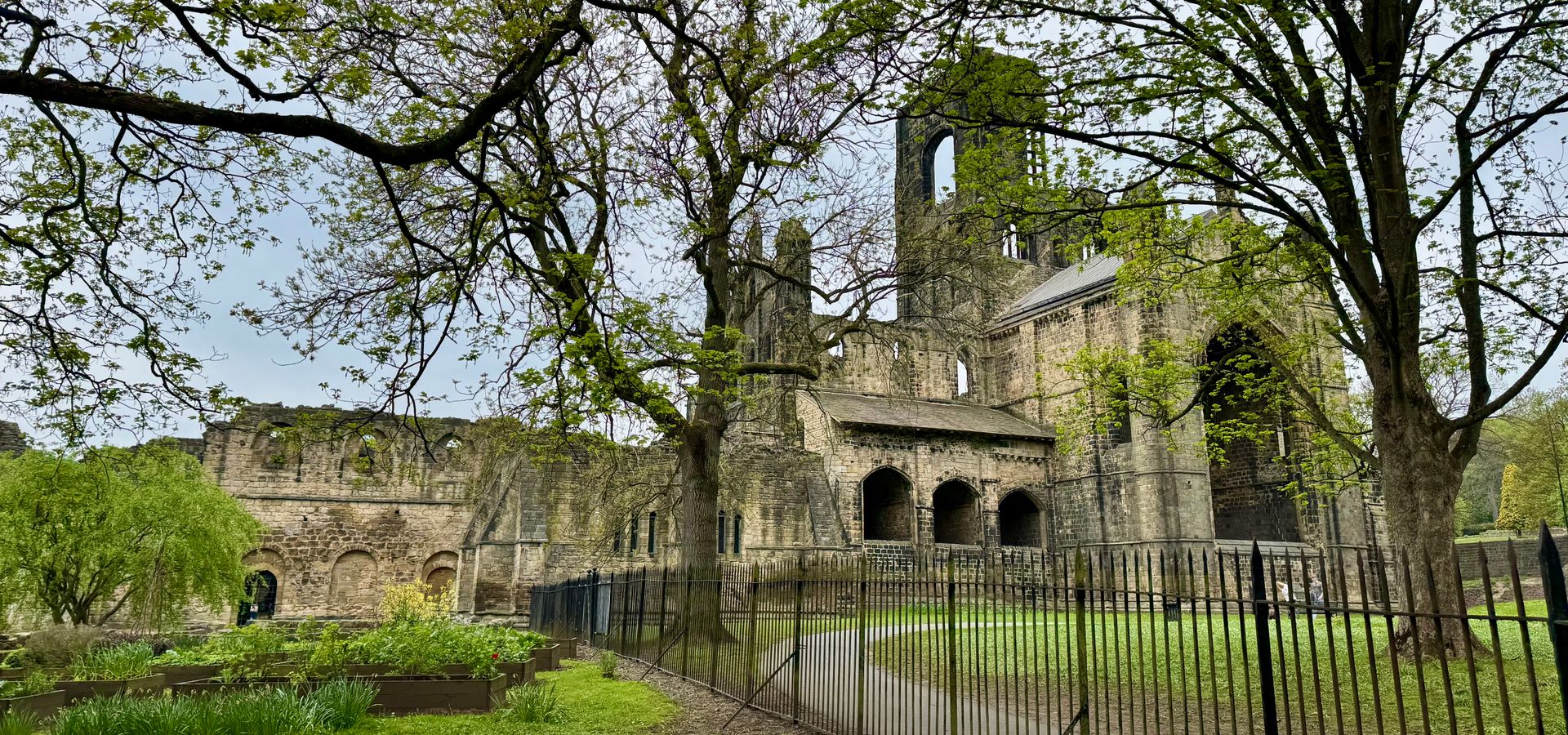 A footpath and fence next to Kirkstall Abbey ruins