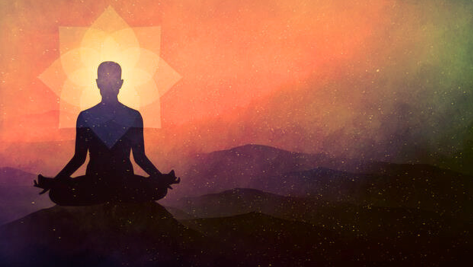 An silhouette of a person sat down with their hands on their knees