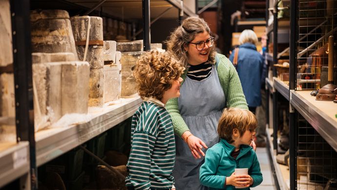 An adult and 2 children looking at display shelves at Leeds Discovery Centre