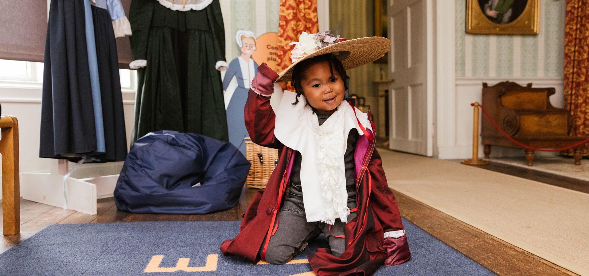 A young girl dresses up in period costumes inside Temple Newsam,