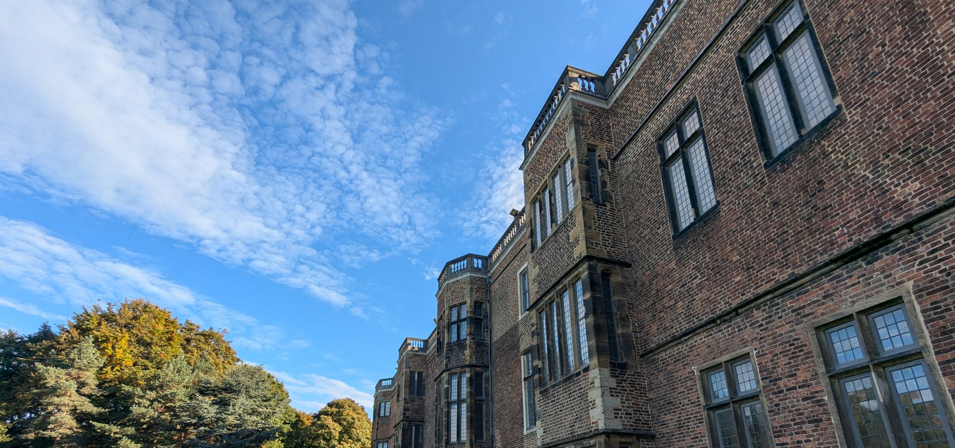 A landscape image of Temple Newsam house on the right and gardens on the left.