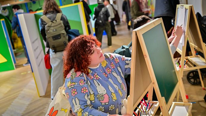 Young person interacting with a chalkboard in the Miffy exhibition