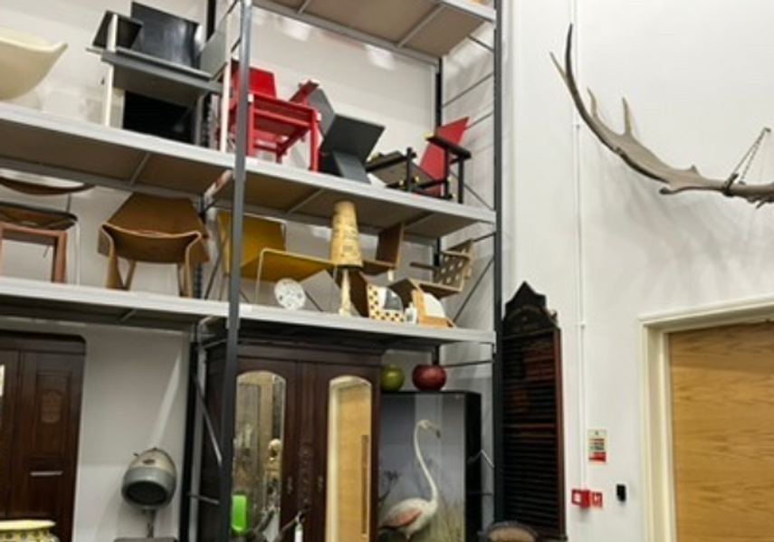 Inside the foyer to the collection store, with tall shelves filled with lots of objects