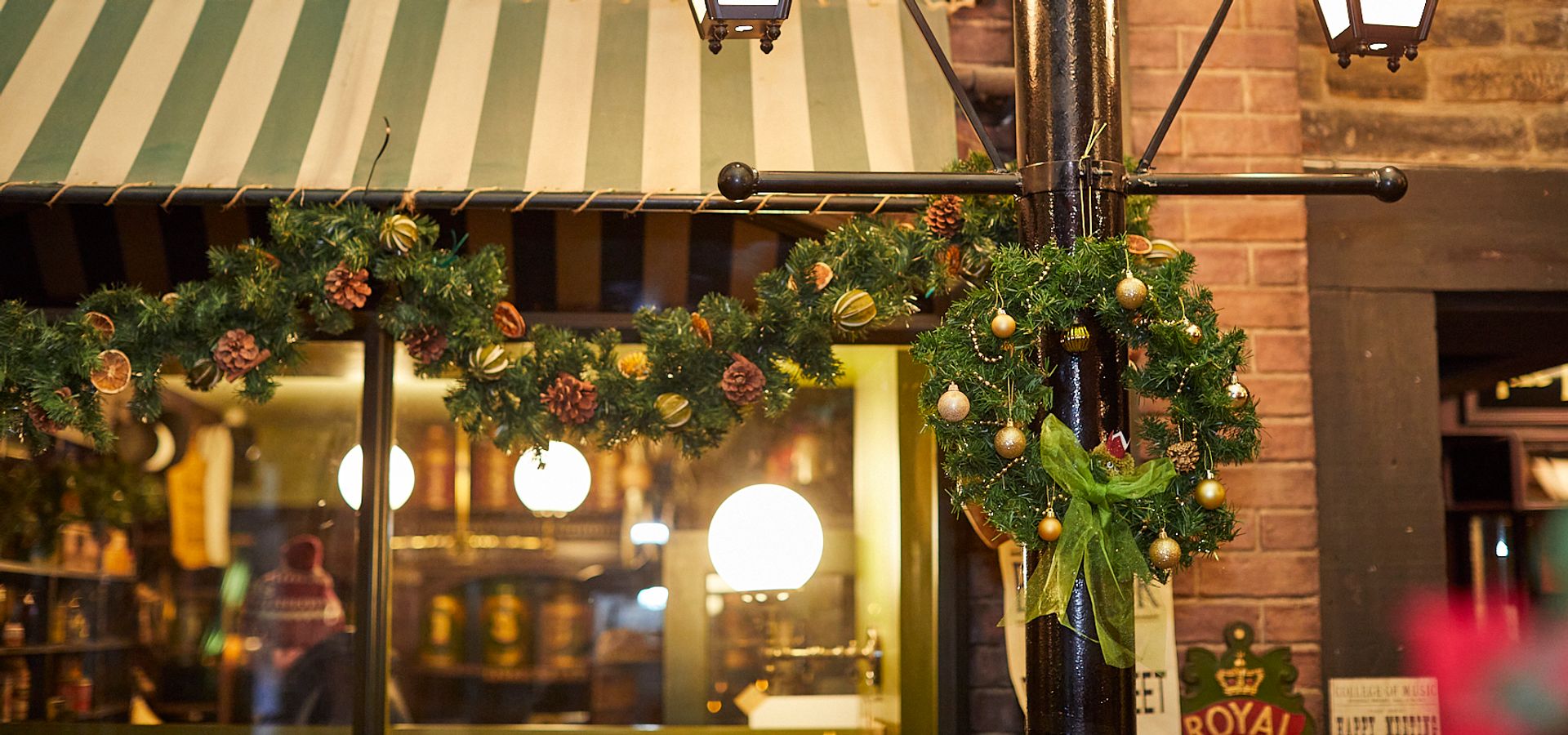 A wreath and christmas garland hanging from a street lamp in Abbey House Museum