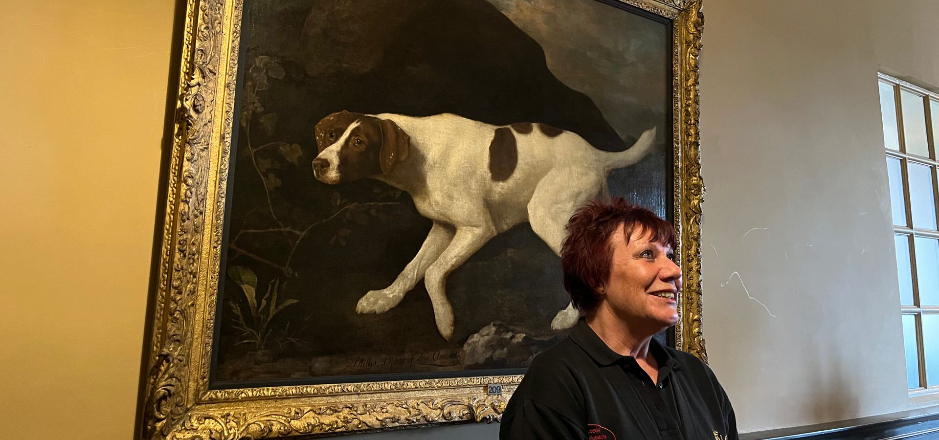 A Visitor Assistant at Temple Newsam stood next an oil painting of Lord Clermont's dog