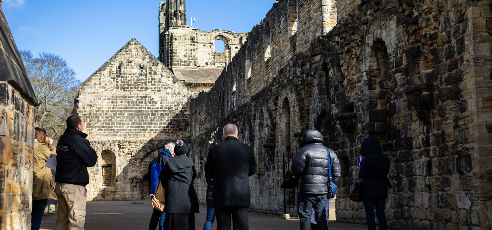 A group walking through Kirkstall Abbey