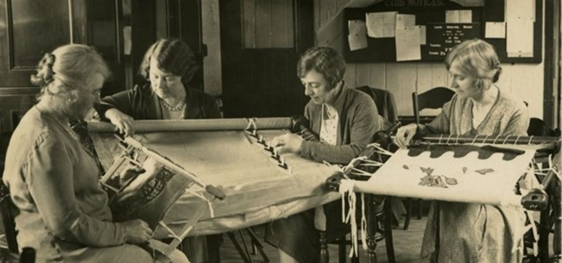 A black and white image of a group of women sewing and stitching