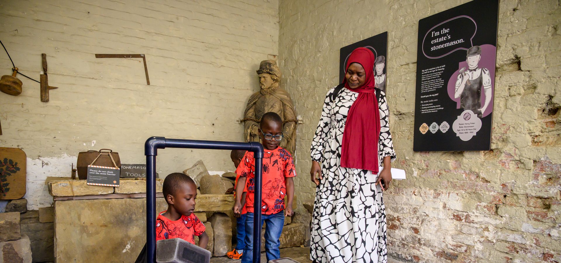 Two children and one adult exploring with machinery at Temple Newsam Home Farm