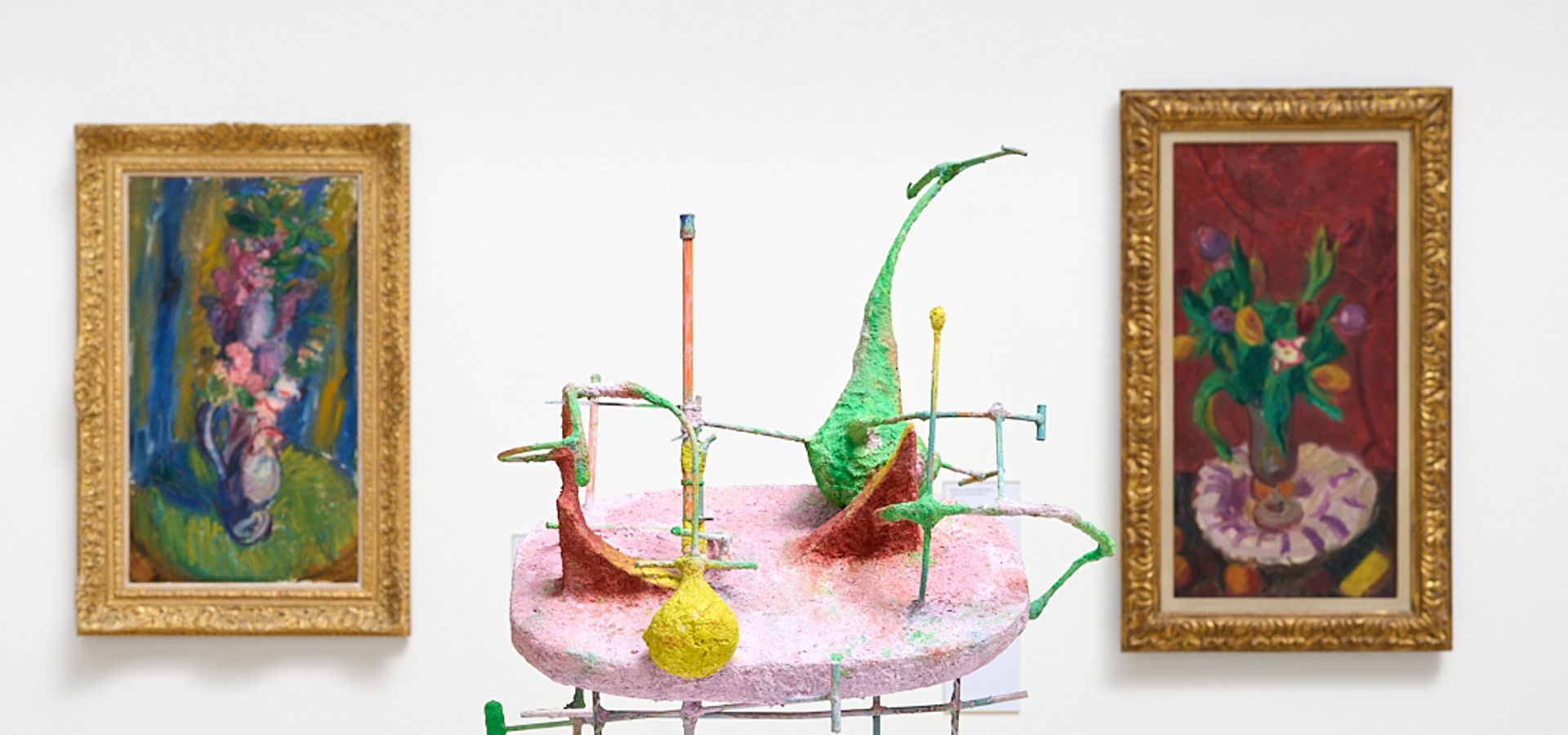 Photograph of two paintings with a sculpture inbetween