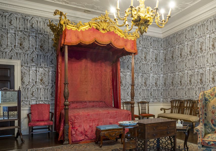 The Gotick Room at Temple Newsam, with a large wooden framed bed with red fabric surrounding