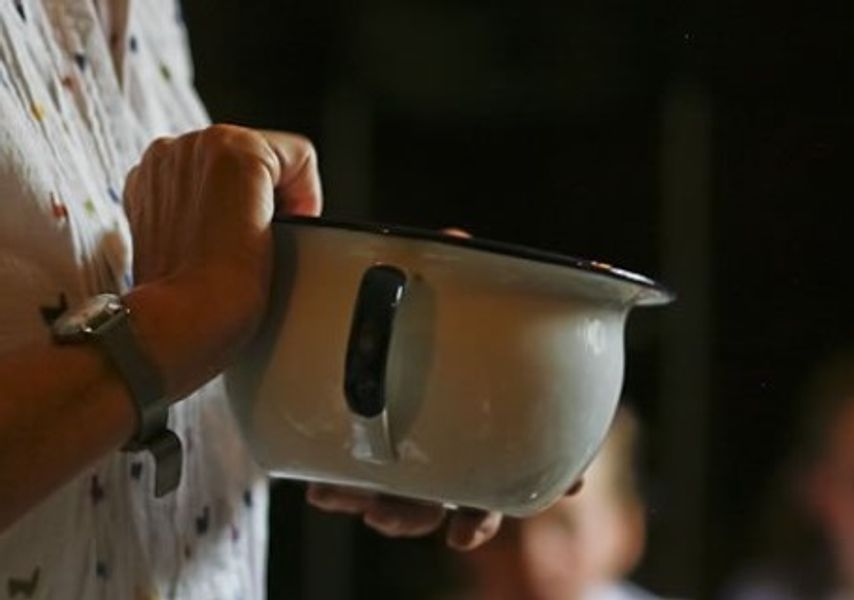 A person holds a ceramic pot