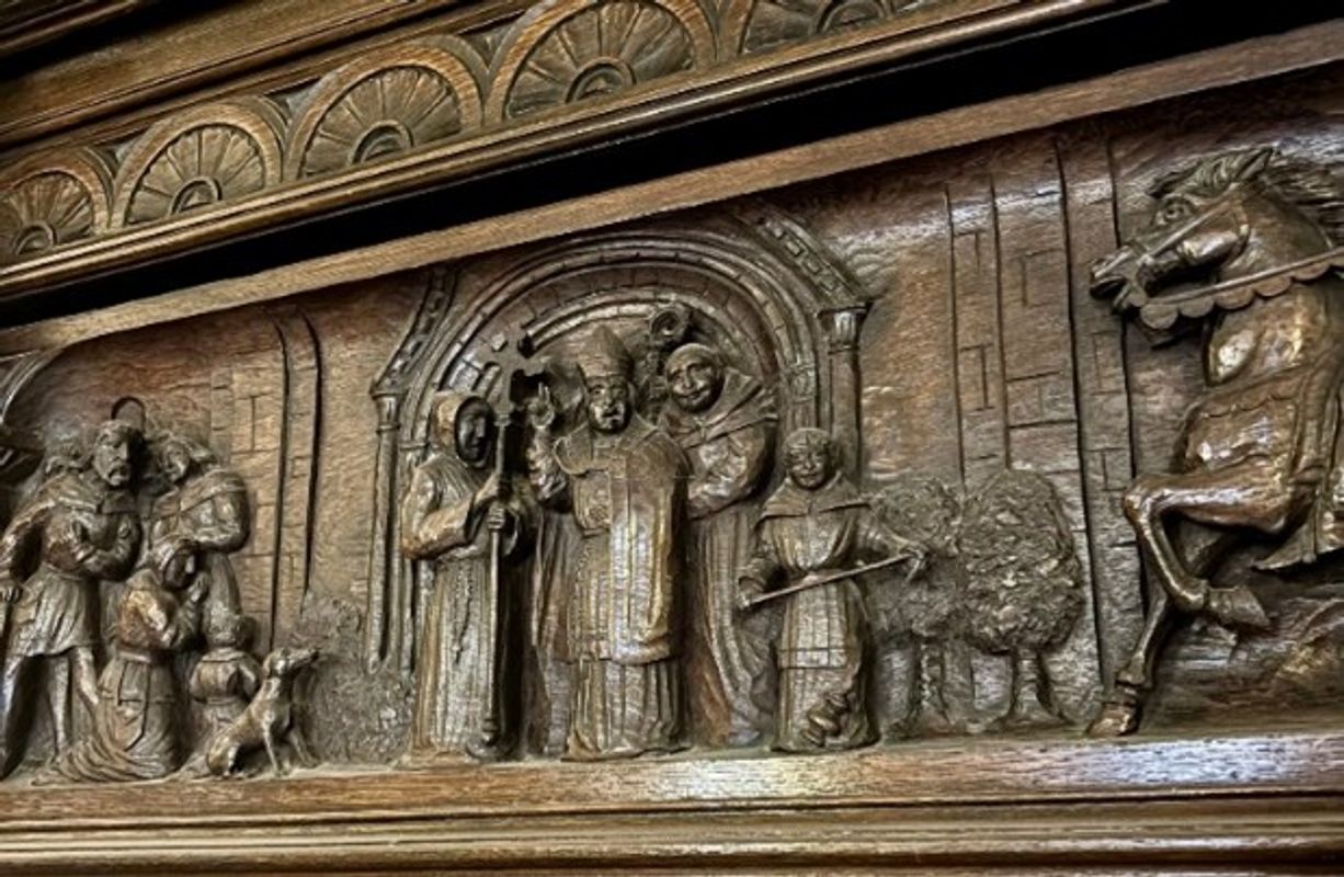 a fireplace featuring a wide carving depicting the surrender of the Abbey in 1539 as part of Henry VIII’s Dissolution of the Monasteries.