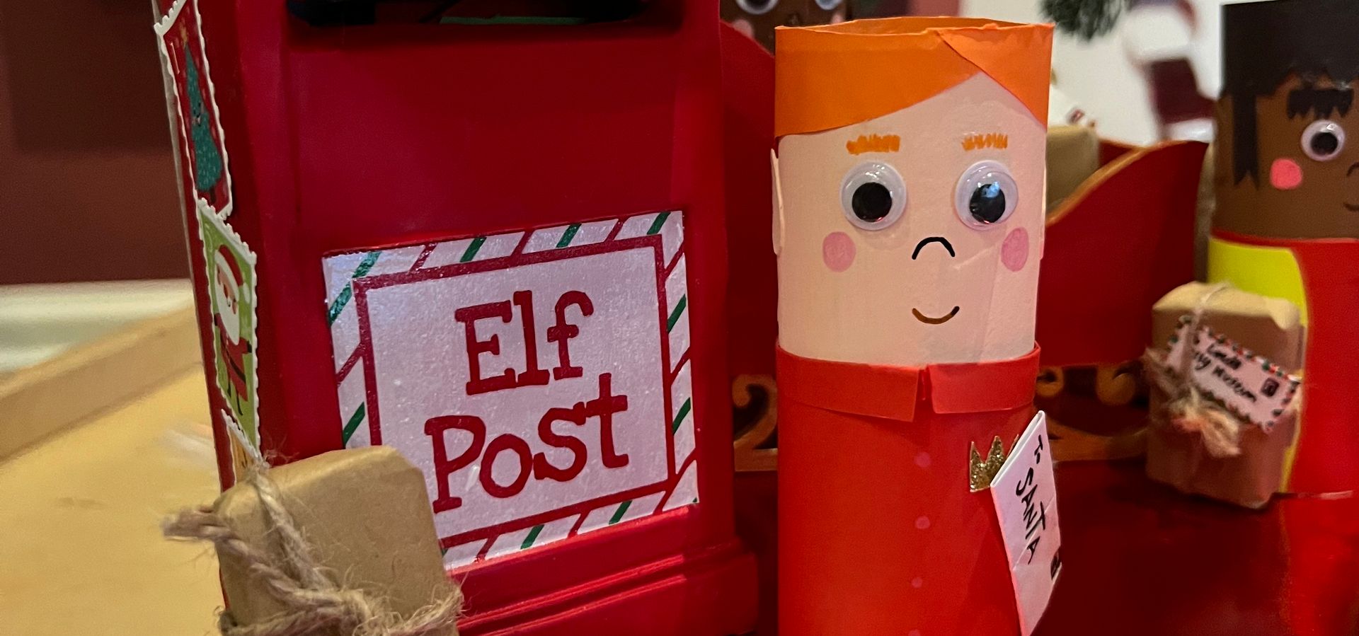 A crafted elf stood with an elf postbox