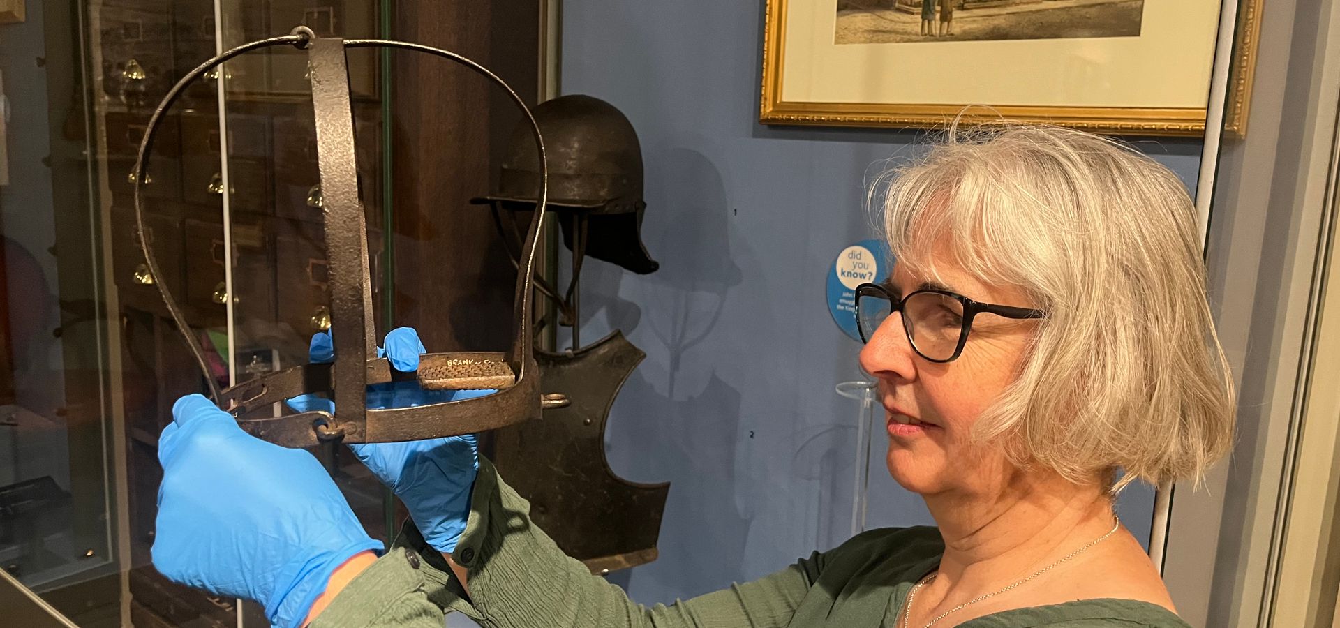 Museum Curator, Kitty Ross, holds up the scold's bridle