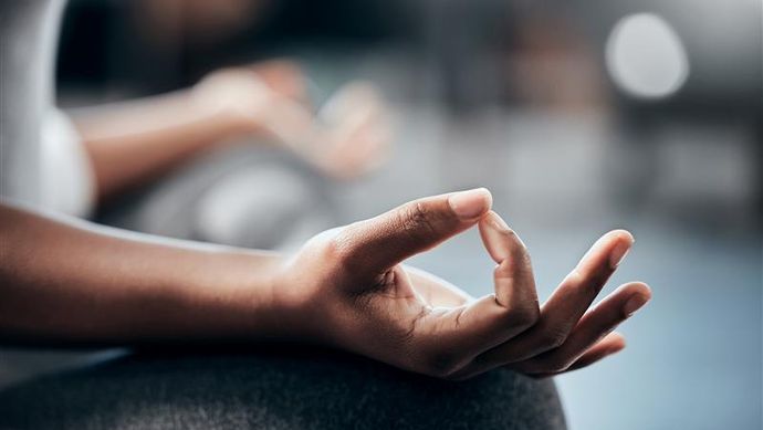 A hand on their knee to meditate
