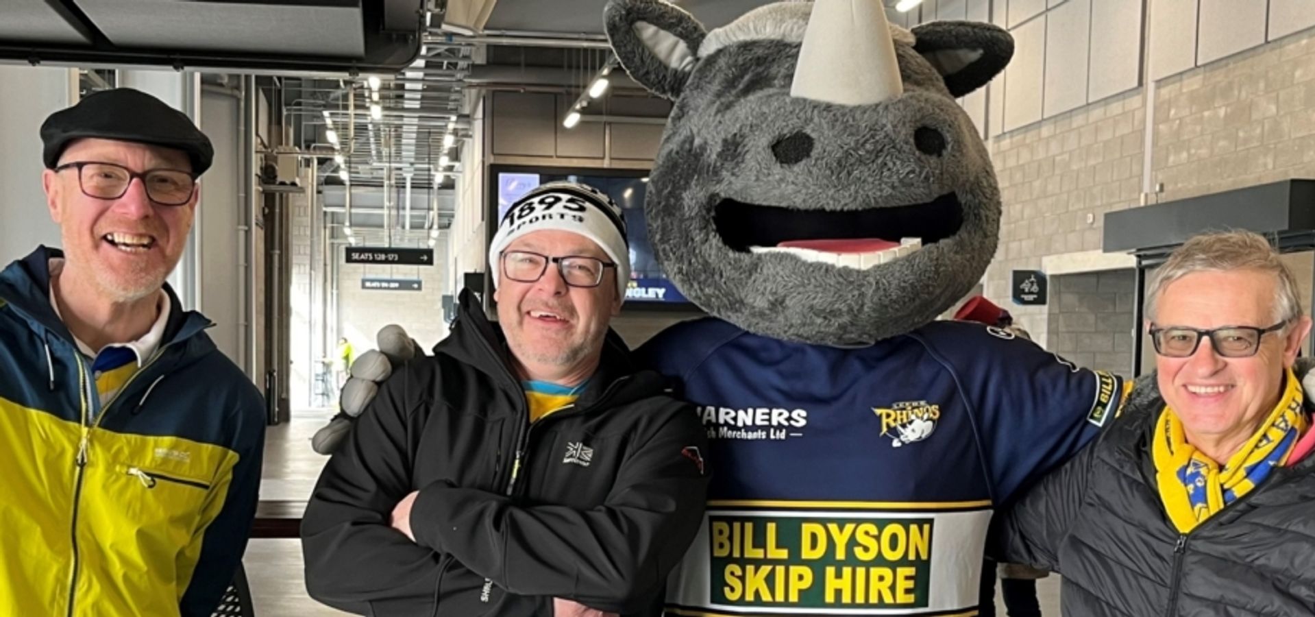 A group of people with the Leeds Rhino mascot