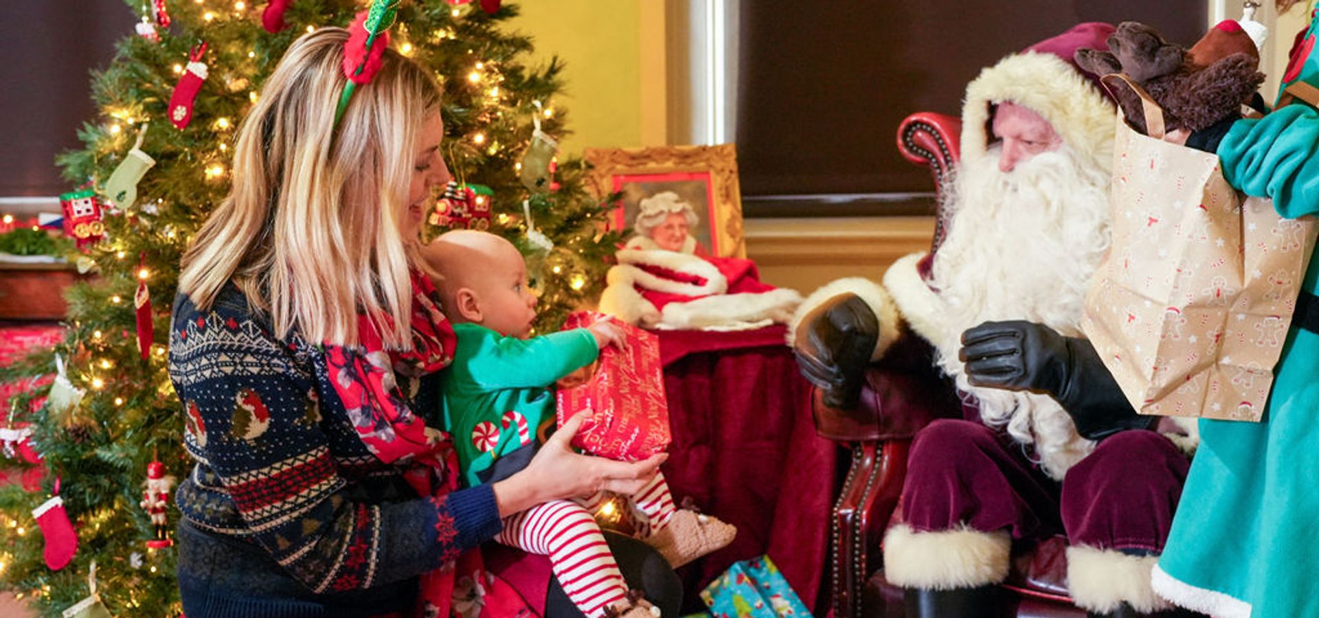 Santa giving a gift to a baby and a woman