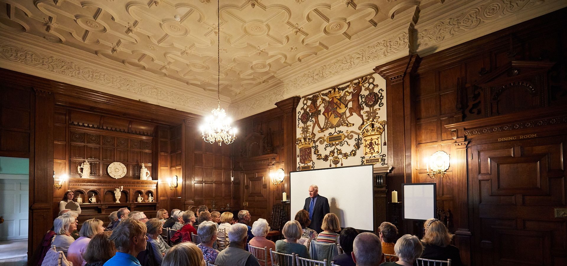 A man talking to a room full of people in Temple Newsam