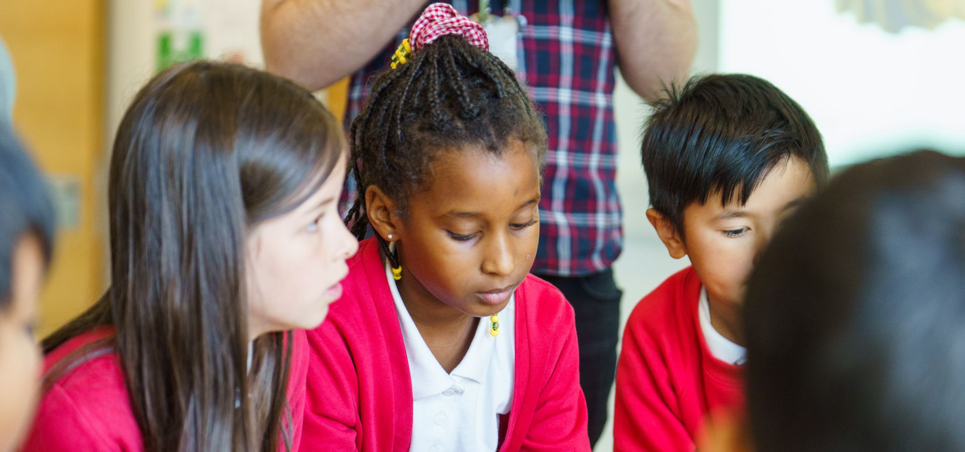 Three school children looking at objects at Leeds Discovery Centre