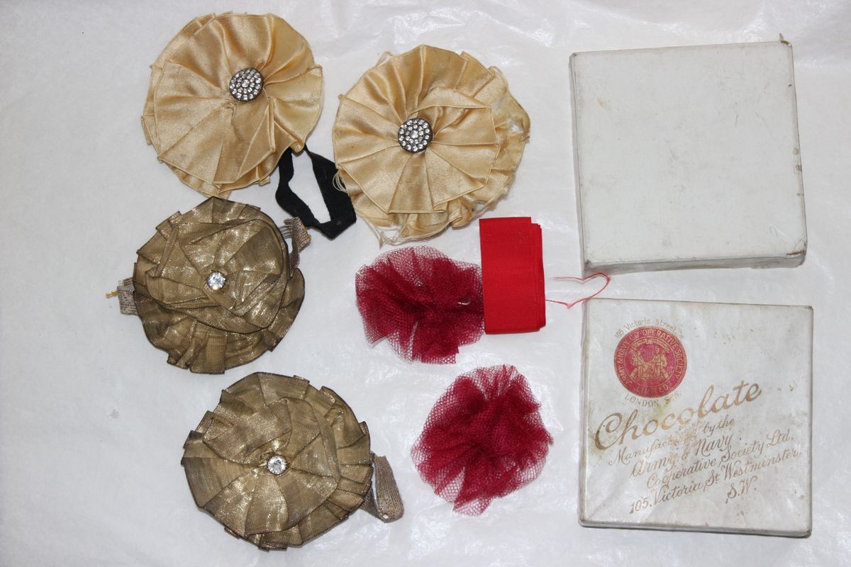 Photograph of old chocolate box with ribbons and buttons inside
