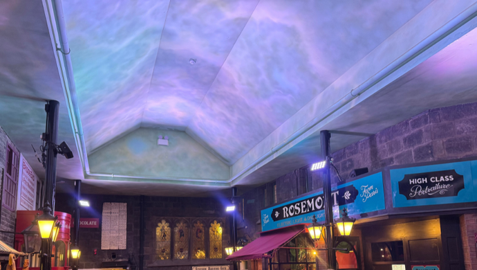 A blue light illumination on a white arched ceiling, above decorated Victorian Streets