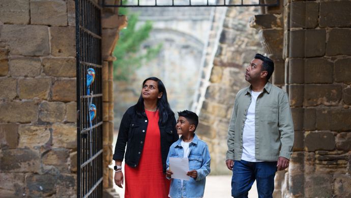 2 adults and a child look around in Kirsktall Abbey