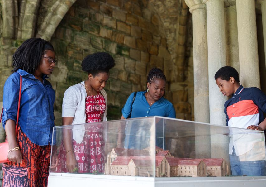 3 adults and a child looking at a replica of Kirkstall Abbey 