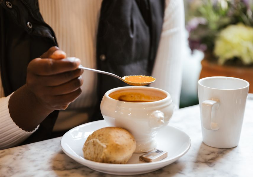 Soup in a bowl with a bread roll