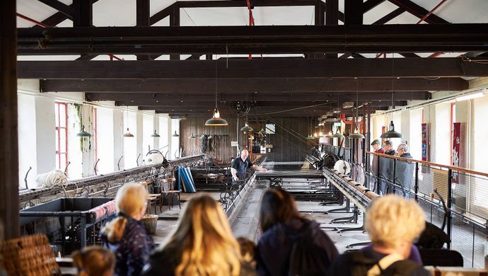 an audience watching a big industrial mule in a mill space