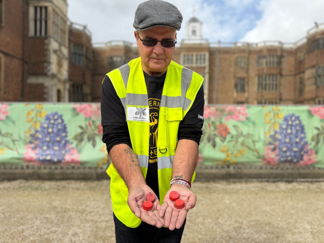 Carl Potter holding objects from the V Festival concert held on the estate in the 1990s in front of Temple Newsam