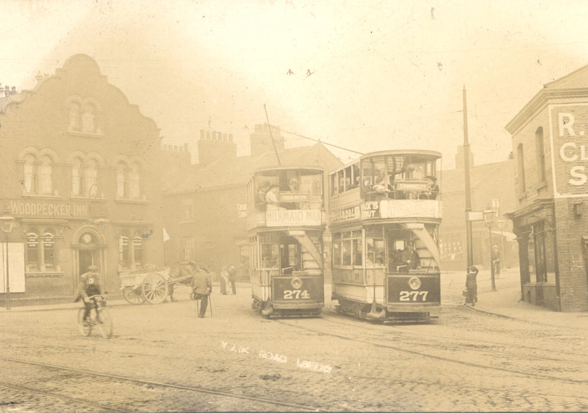 Sepia photo of a street in Leeds with double decker trams