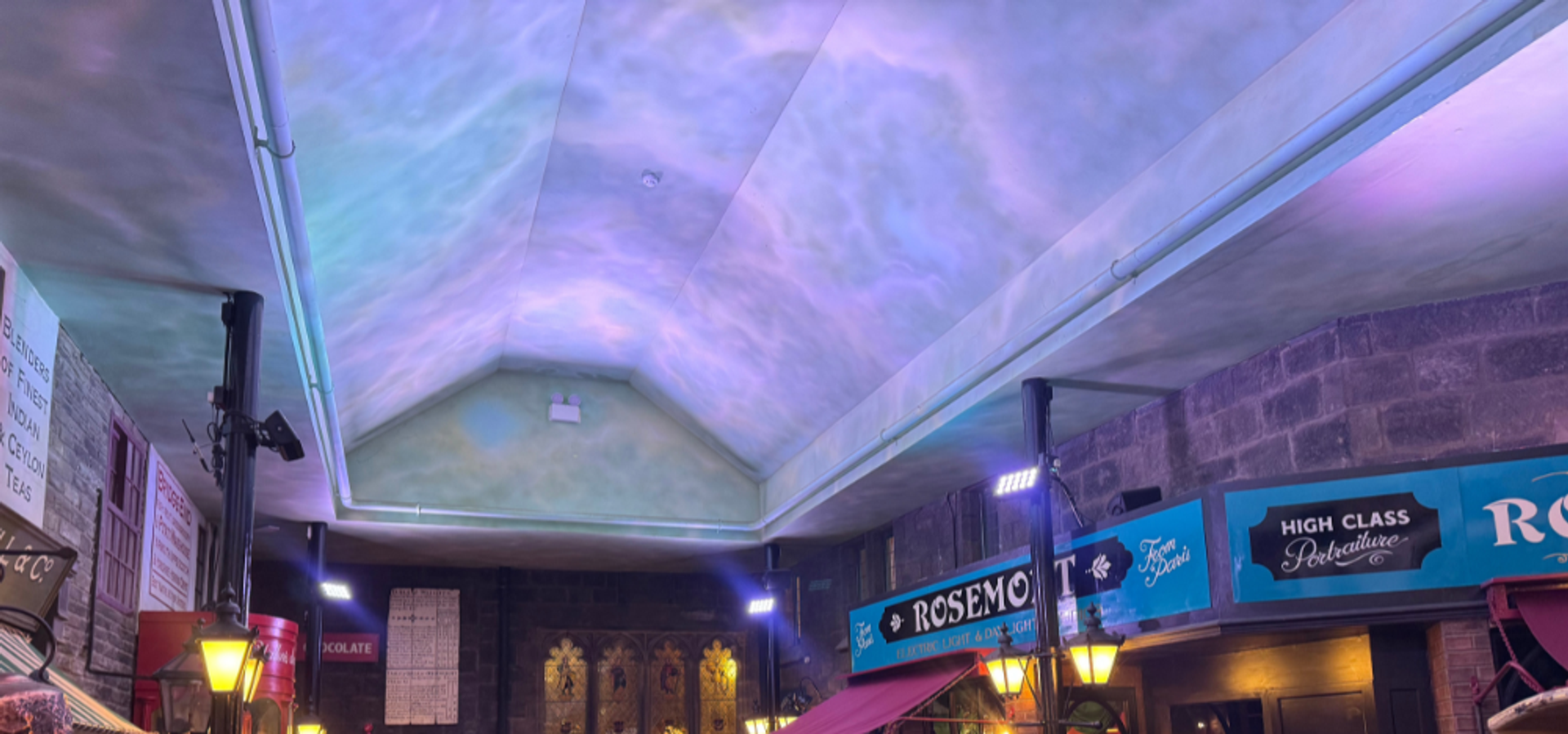 A blue light illumination on a white arched ceiling, above decorated Victorian Streets