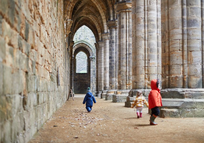 A couple of children walk through Kirkstall Abbey