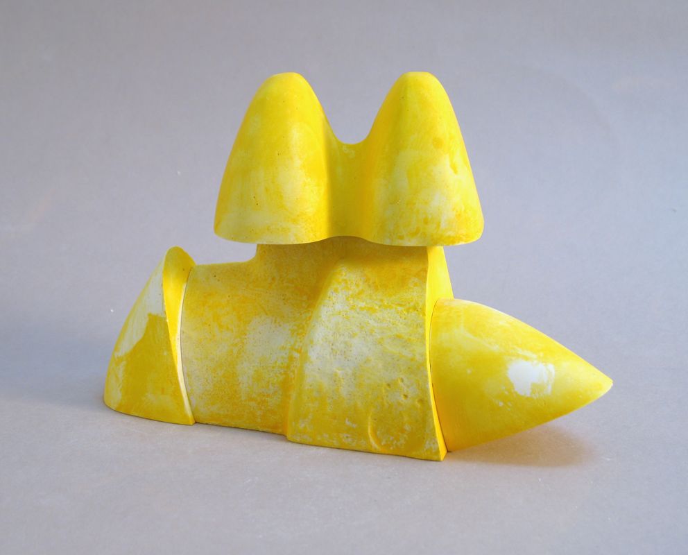 A bright yellow abstract sculpture by Garth Evans