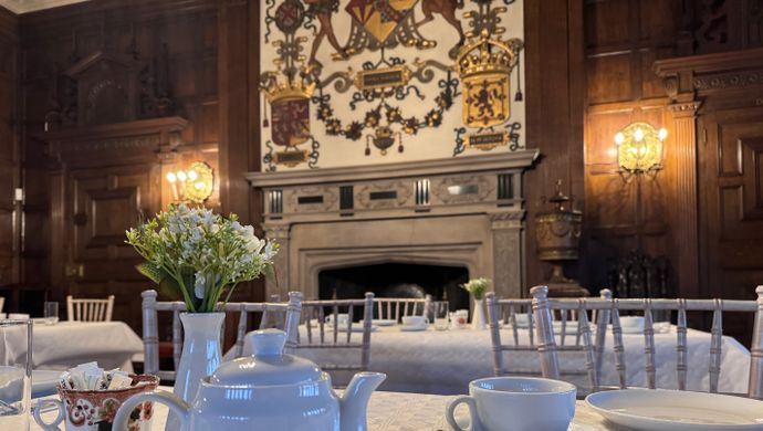 A tea pot and tea mugs on a table infront of a fire place at Temple Newsam