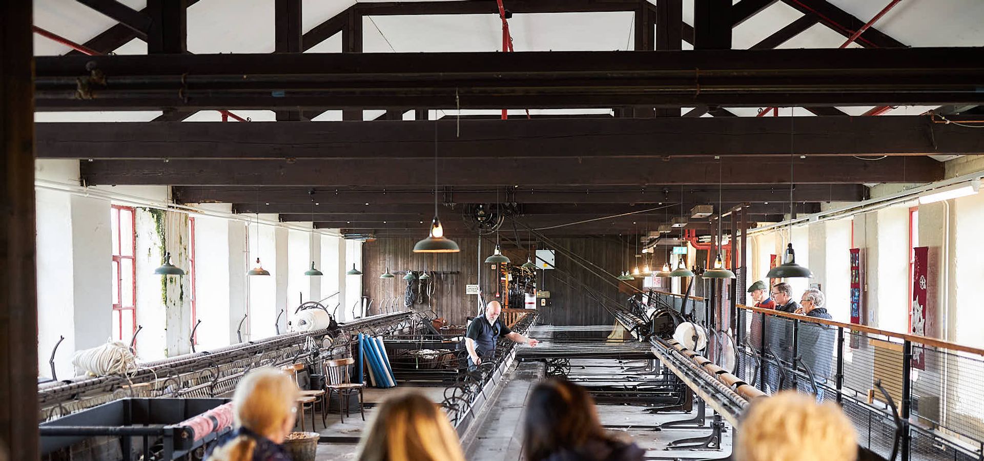 an audience watching a big industrial mule in a mill space