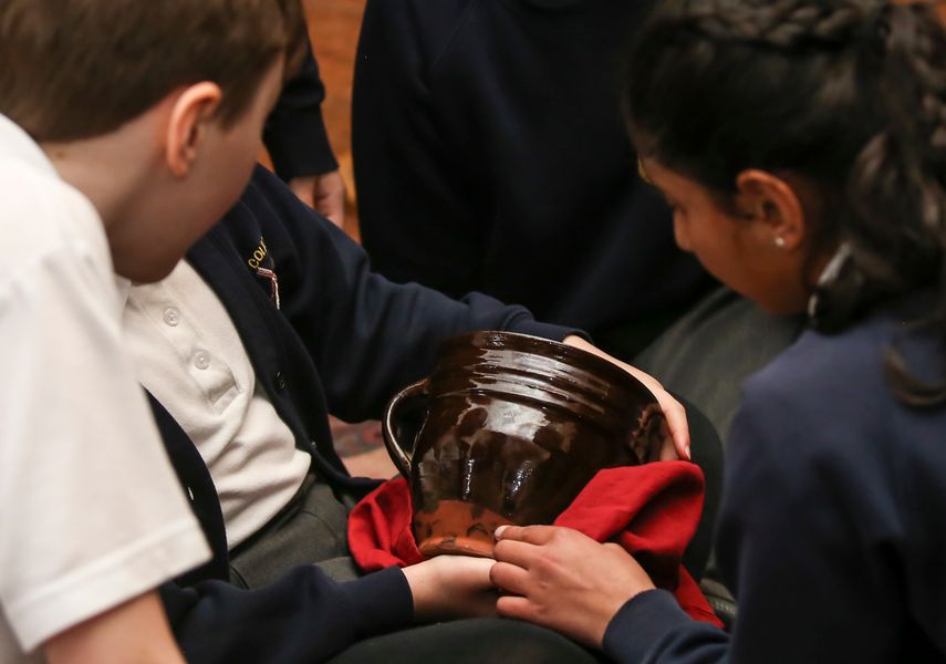 image of school children handling a museum object