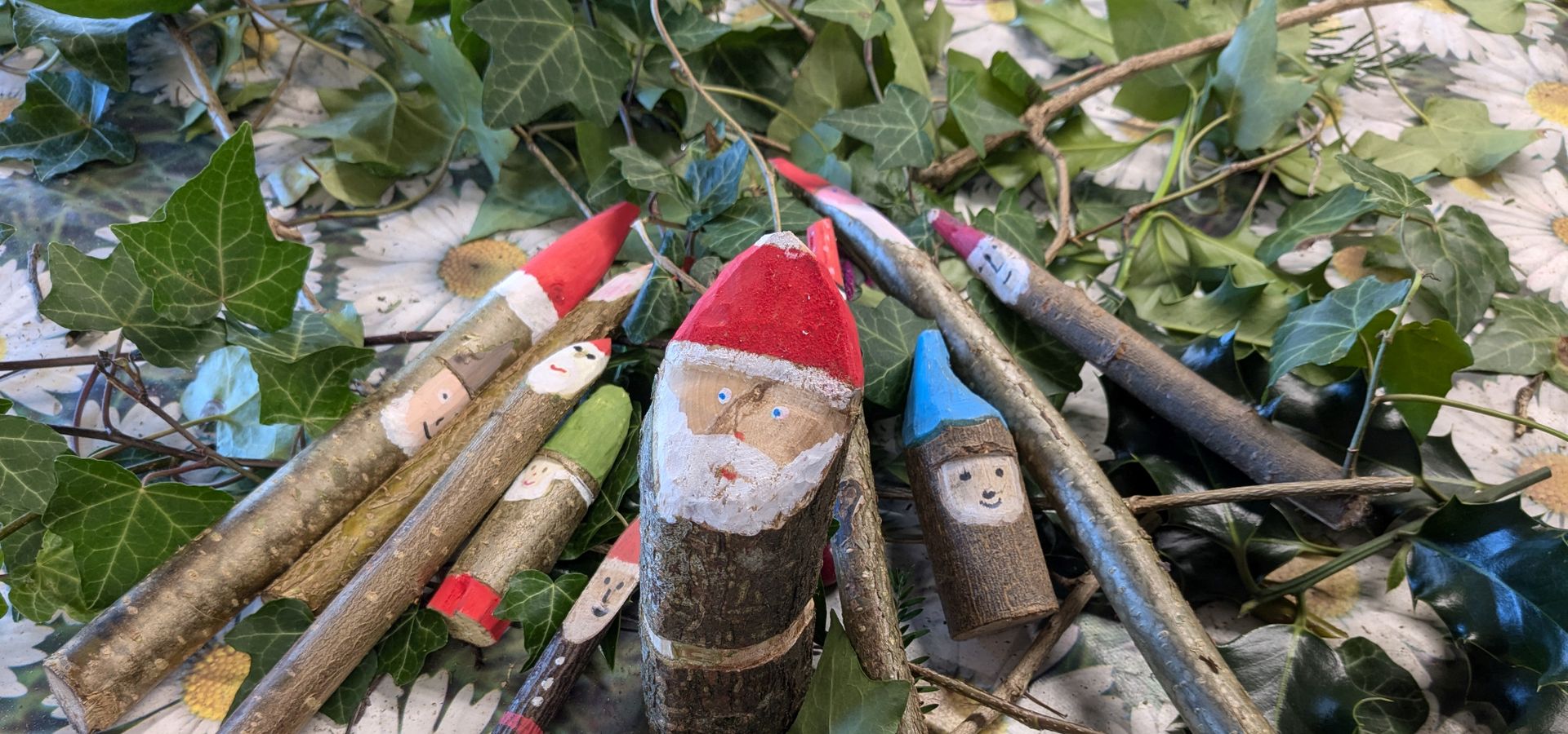 Santa decorations made from sticks on a pile of sticks