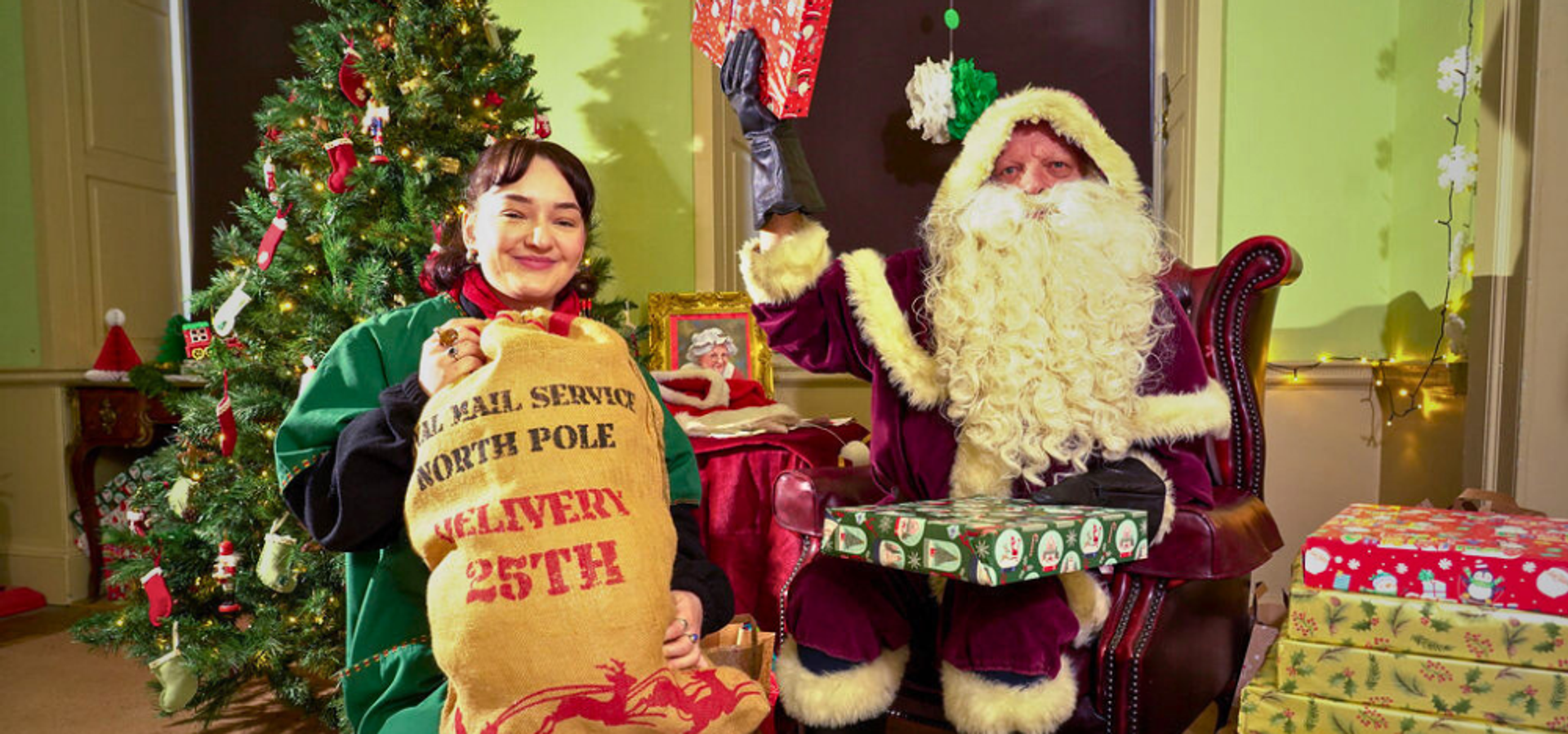 santa and an elf holding presents