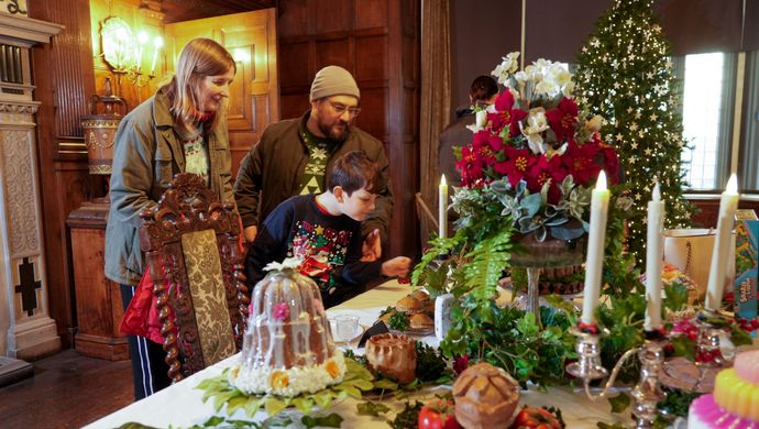 A group of people admiring a festive feast display in the Dining Room of Temple Newsam