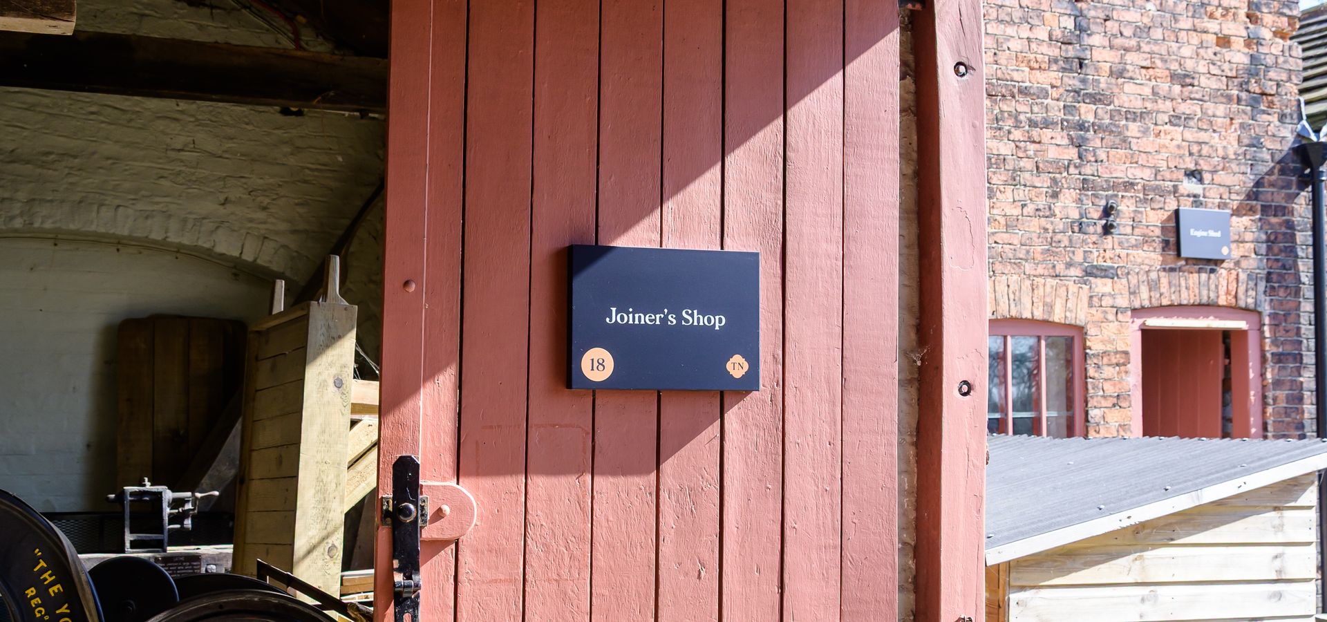 Red door at Home Farm with a sign saying Joiners Shop