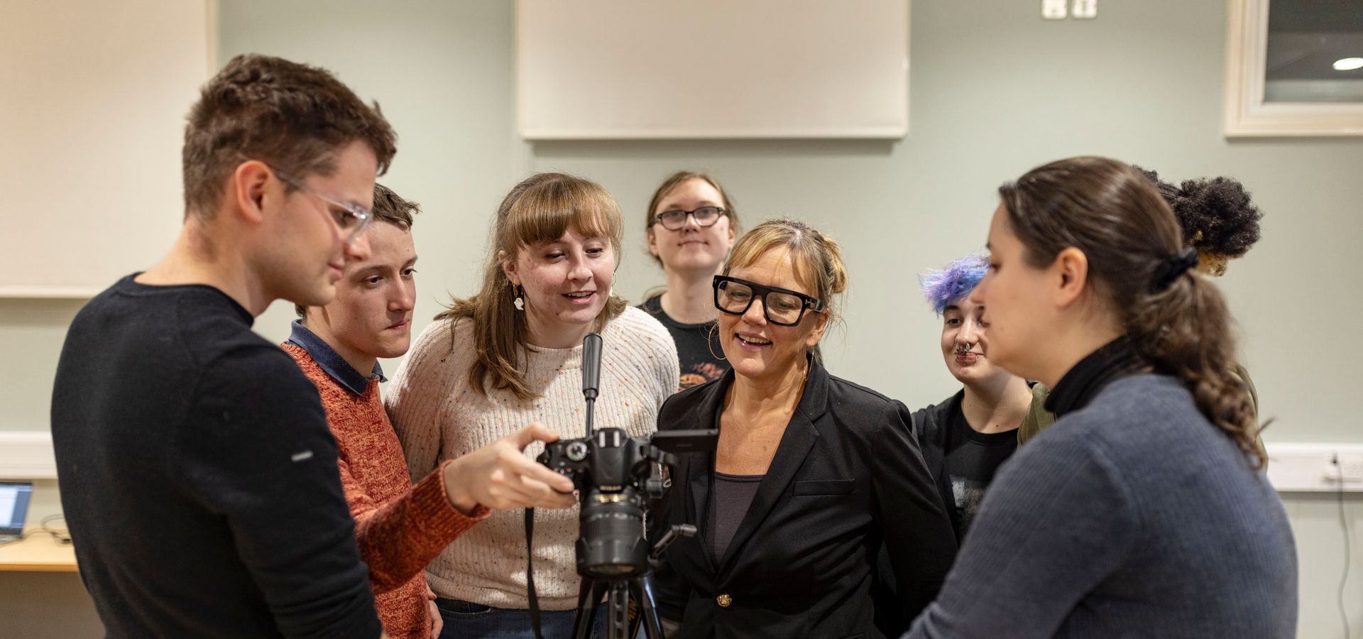 A group of Preservative Party members looking around a filming camera
